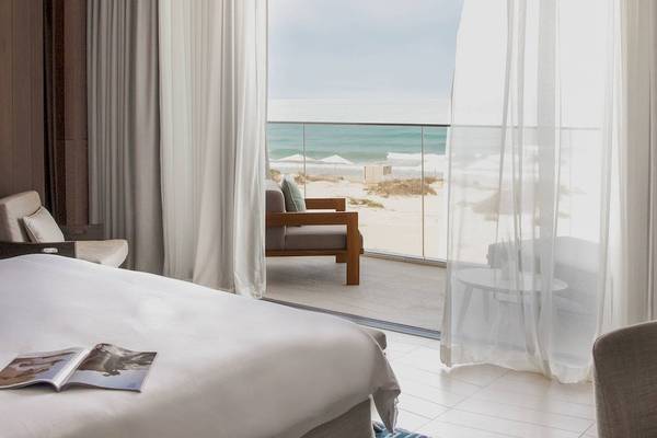 Bett im Hotelzimmer des Jumeirah at Saadiyat Island Resort mit Ausblick auf den Strand.