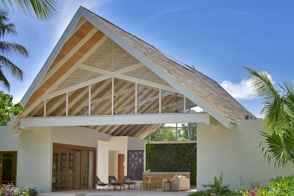 Außenansicht der Kandima Maldives Villa mit offenem Dach und tropischen Pflanzen.