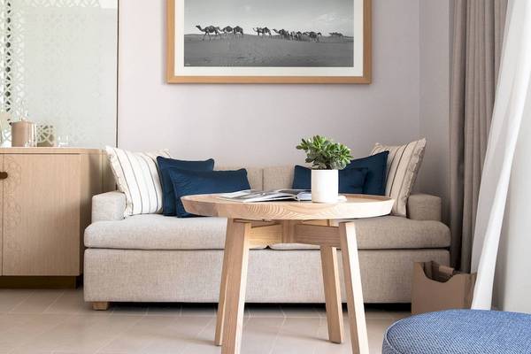 Ein Wohnzimmer im Jumeirah at Saadiyat Island Resort mit einem Sofa, einem Tisch und einer Wand mit einem Kamelbild.