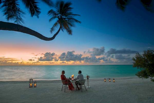 Paar genießt Abendessen am Strand im Kandima Maldives