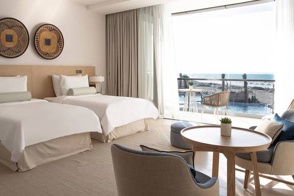 Doppelbettzimmer im Jumeirah at Saadiyat Island Resort mit Blick auf den Ozean und eine Terrasse.