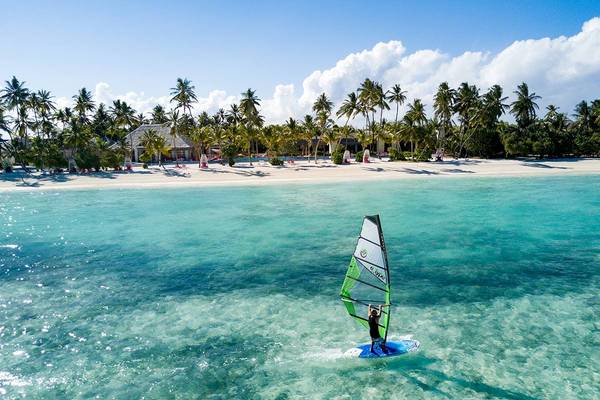 Windsurfer im Wasser vor dem Strand des Kandima Maldives Hotels