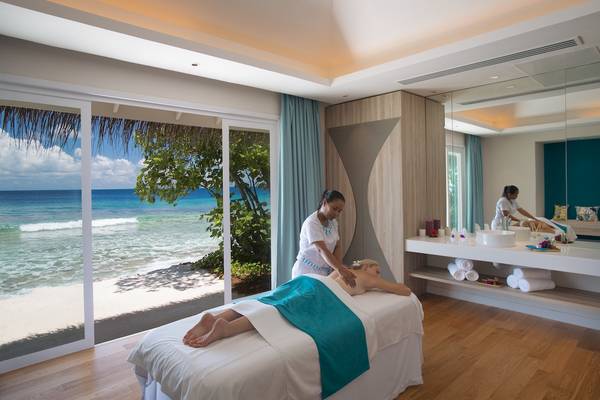 Massagebehandlung am Strand im Kandima Maldives Hotel mit Blick auf das Meer.
