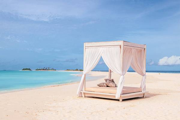 Ein Bett auf dem Strand des Finolhu Baa Atoll auf den Malediven.