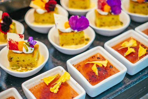 Mehrere Desserts in kleinen weißen Schalen auf einem Tablett im Finolhu Baa Atoll Hotel auf den Malediven.