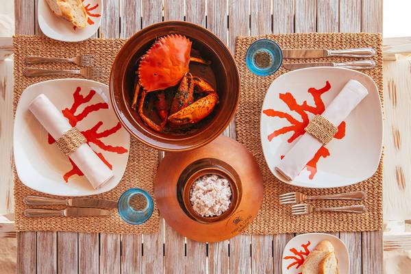 Ein Tisch mit Essen im Hotel Finolhu Baa Atoll Maldives, inklusive Teller, Krabbensuppe, Reis und Besteck.