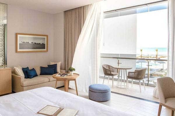 Innenansicht eines Hotelzimmers im Jumeirah at Saadiyat Island Resort mit Blick auf die Terrasse und das Meer.