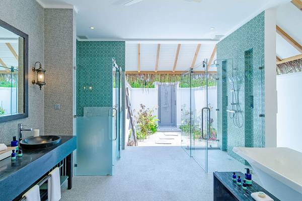 Badezimmer im Finolhu Baa Atoll Maldives Hotel mit blauen Fliesen und Glasdusche.