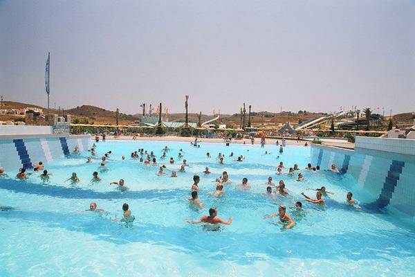 Atlantis Beach Hotel - Kos Pool mit vielen Schwimmern und Wasserrutschen im Hintergrund.