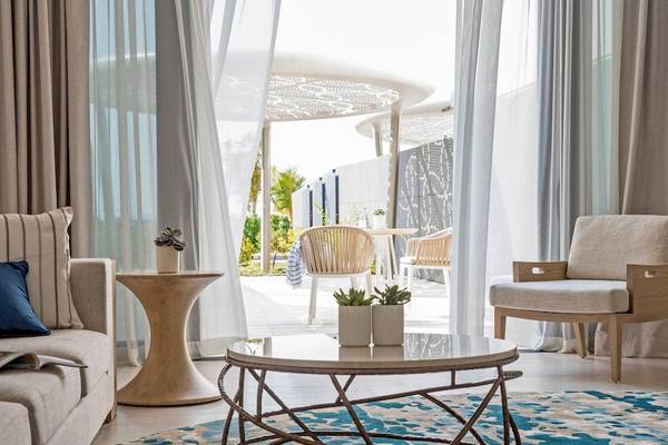 Wohnzimmer im Jumeirah at Saadiyat Island Resort mit moderner Einrichtung und offenem Zugang zur Terrasse.