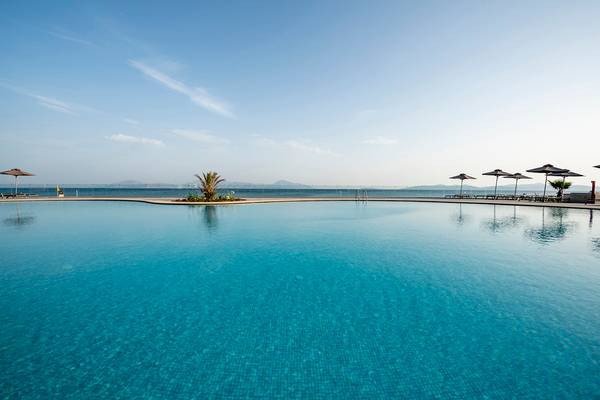 Pool des Horizon Beach Resorts mit Blick auf das Meer und Sonnenschirmen