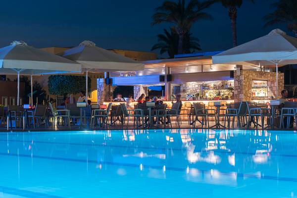 Poolbar des Horizon Beach Resorts bei Nacht mit Gästen unter Sonnenschirmen