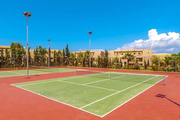 Tennisplatz im Horizon Beach Resort mit zwei Plätzen, umgeben von Gebäuden und Bäumen.