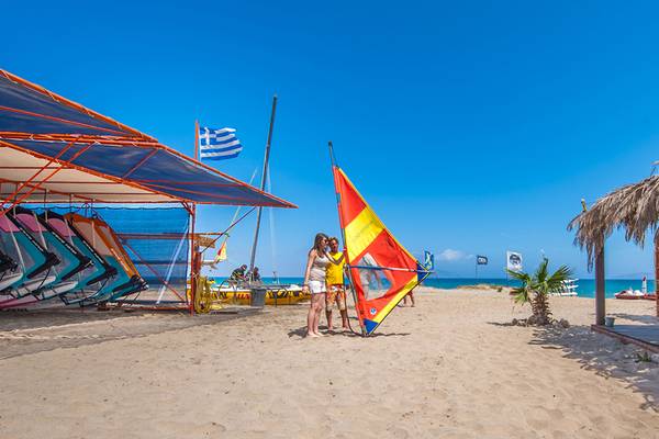 Zwei Personen am Horizon Beach Resort mit Windsurf-Segel im Sand