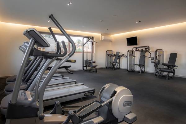 Fitnessraum im Horizon Beach Resort mit Laufbändern, Kraftgeräten und Fernseher.
