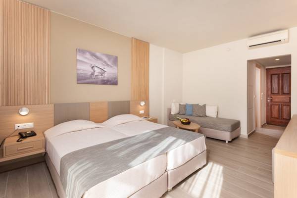 Doppelbettzimmer im Horizon Beach Resort Hotel mit Nachttisch und Sofa.