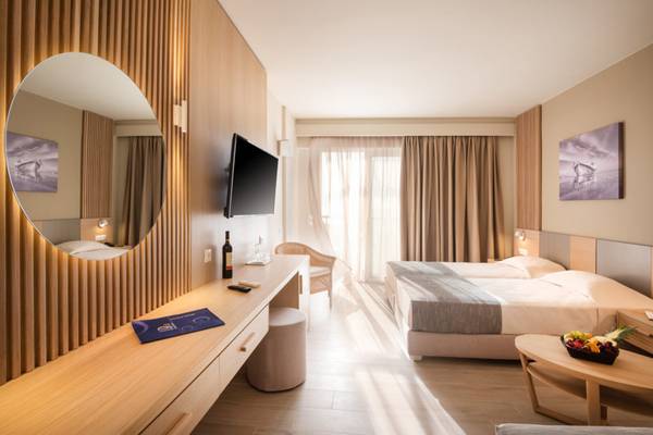 Ein modernes Hotelzimmer im Horizon Beach Resort mit einem großen Bett, Fernseher und Schreibtisch.