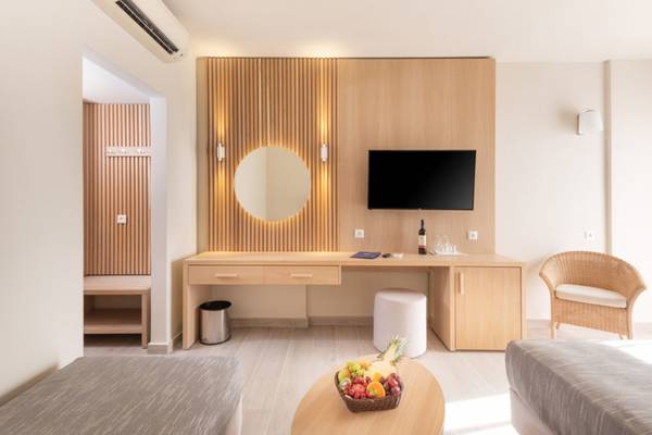 Innenansicht eines Zimmers im Horizon Beach Resort mit Schreibtisch, Fernseher und Obstkorb.