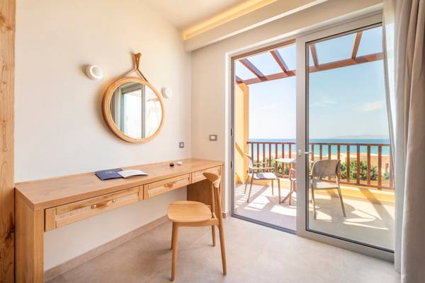Arbeitsbereich mit Schreibtisch und Stuhl in einem Zimmer des Horizon Beach Resorts mit Blick auf die Terrasse und das Meer.