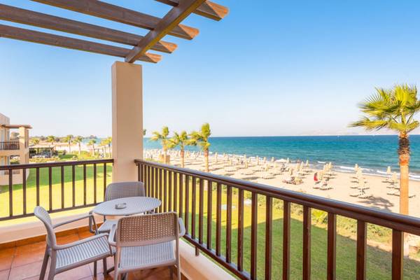 Blick von der Balkon des Horizon Beach Resorts auf den Strand mit Palmen und Sonnenliegen.