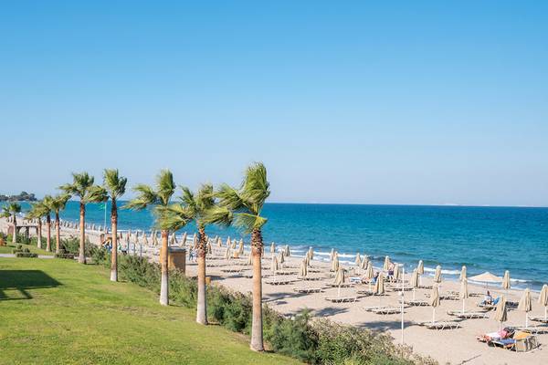Blick auf den Strand des Horizon Beach Resorts mit Palmen, Sonnenliegen und blauem Meer