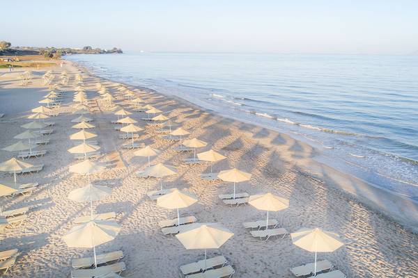 Strand des Horizon Beach Resorts mit vielen Sonnenschirmen und Liegen.