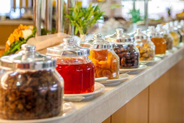 Buffet mit verschiedenen Snacks im Horizon Beach Resort, darunter Aprikosen und getrocknete Früchte in Gläsern.