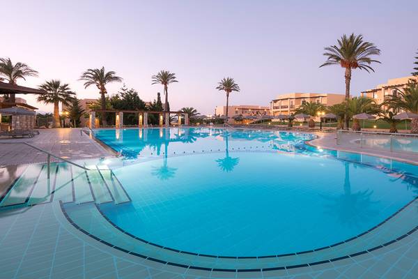 Außenpool des Horizon Beach Resorts bei Abendbeleuchtung mit Palmen und Gebäuden im Hintergrund.