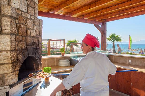 Koch im Horizon Beach Resort bei der Zubereitung von Pizza im Ofen am Strand