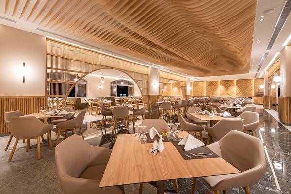 Innenansicht des Restaurants im Horizon Beach Resort mit hölzerner Decke und runden Tischen.