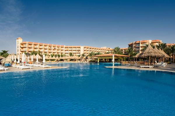 Außenpool des Siva Grand Beach Hotel mit Loungeliegen und Sonnenschirmen.