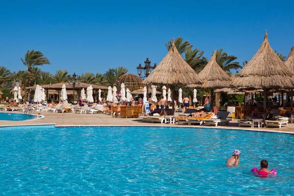 Außenpoolbereich des Siva Grand Beach Hotels mit Sonnenschirmen und Liegestühlen.