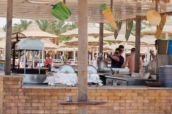 Terrasse des Siva Grand Beach Hotel mit Essensstation und Sonnenschirmen