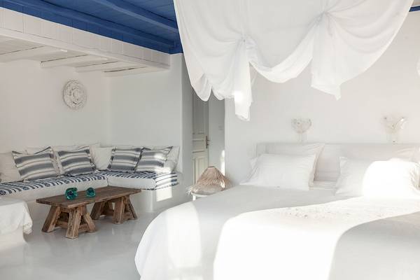 Schlafzimmer im Grecotel Mykonos Blu mit weißen Möbeln und blauer Decke