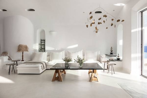 Weißes Wohnzimmer im Grecotel Mykonos Blu Hotel mit modernem Möbeln und Blick aufs Meer.