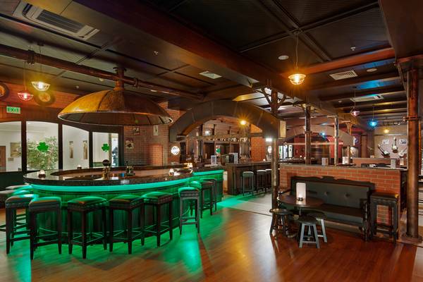 Innenbereich der Bar im Diamond Excellence Resort & Spa mit grüner Beleuchtung und Holzboden.