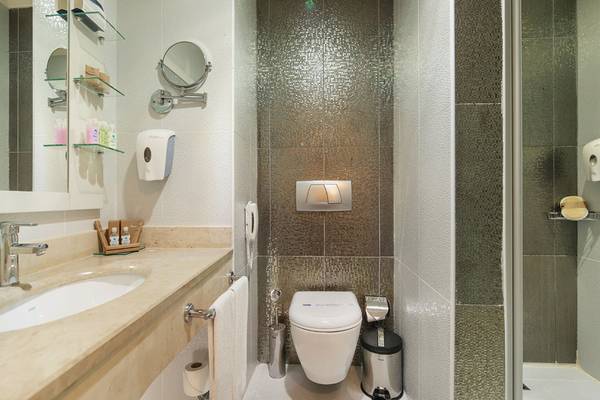 Badezimmer des Diamond Excellence Resort & Spa mit Marmorwaschbecken, Spiegel und Dusche.
