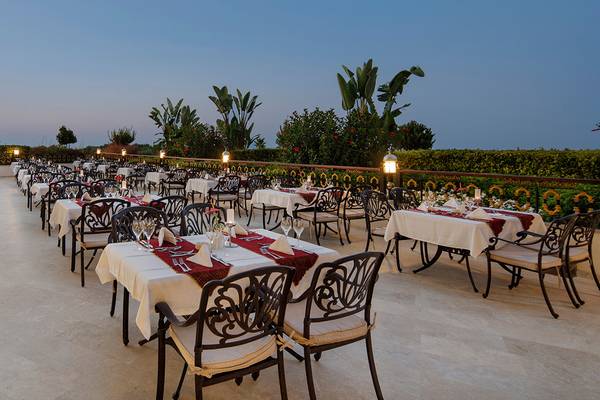 Außenbereich des Diamond Excellence Resort & Spa mit vielen gedeckten Tischen und Stühlen.