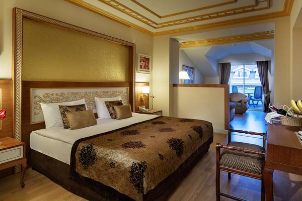 Hotelzimmer des Diamond Excellence Resort & Spa mit Bett, Dekor und Balkonzugang.