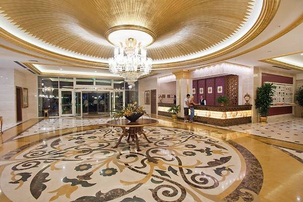 Innenansicht der Lobby des Diamond Excellence Resort & Spa mit einem großen Kronleuchter, Marmorboden und Empfangstresen.