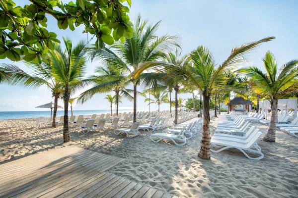 Strand des Viva Wyndham V Heavens Hotels mit vielen Liegestühlen und Palmen