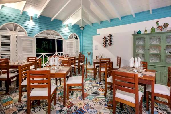 Innenansicht des Viva Wyndham V Heavens Restaurants mit blauen Wänden, Holztischen und Stühlen sowie buntem Boden.