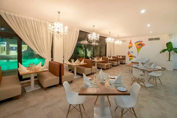 Innenansicht des Restaurants im Viva Wyndham V Heavens Hotel mit eleganten Tischen und Stühlen.