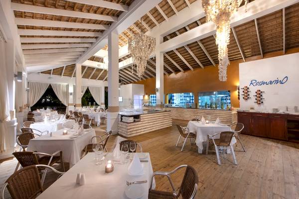 Innenansicht des Rosmarino Restaurants im Viva Wyndham V Heavens Hotel mit weißen Tischen und Stühlen.