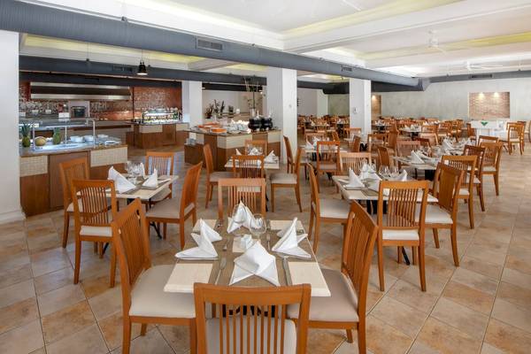 Innenansicht des Restaurants im Viva Wyndham V Heavens Hotel mit gedeckten Tischen und Stühlen.