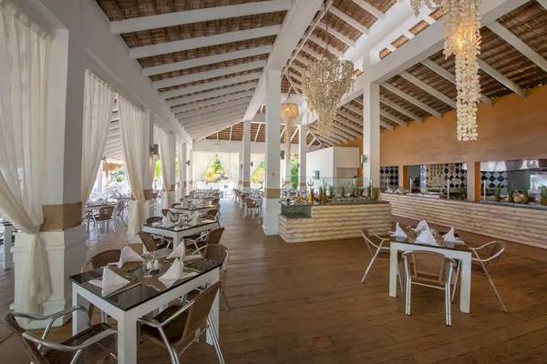 Innenansicht des Restaurants im Viva Wyndham V Heavens Hotel mit Tisch und Stühlen.