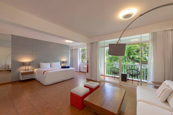 Viva Wyndham V Heavens Hotelzimmer mit Bett, Balkon und Wohnzimmer.