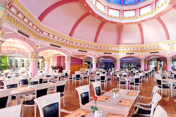Innenansicht des Kamelya Aishen K Club Restaurants mit rosa Säulen und einer blauen Kuppel.