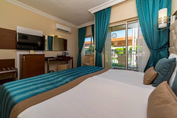Doppelzimmer im Kamelya Aishen K Club Hotel mit Bett, Fernseher und Balkon.
