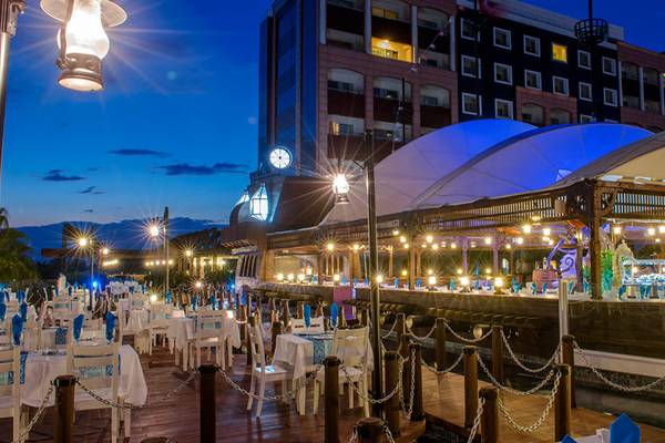 Dinnerbereich des Kamelya Aishen K Club Hotels bei Nacht, mit vielen gedeckten Tischen und leuchtenden Lichtern.